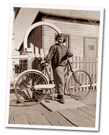 My mom as a young girl standing with her spiffy bicycle.
