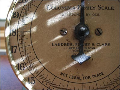 Sun streaks across dial of vintage kitchen scale. Calgary. 17 February 2002. Copyright © 2002 Grant Hutchinson