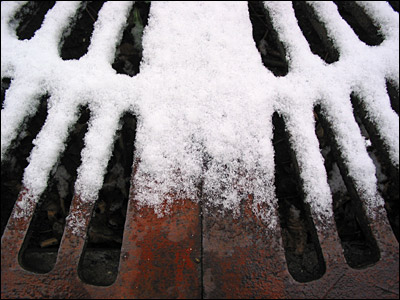 Snow melting on metal grate. 5th Avenue Southwest, Calgary. 21 October 2002. Copyright © 2002 Grant Hutchinson